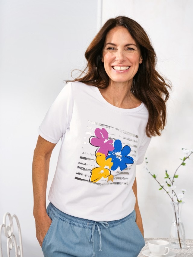 Lächelnde Frau trägt das Baumwoll-Shirt Blumenwiese