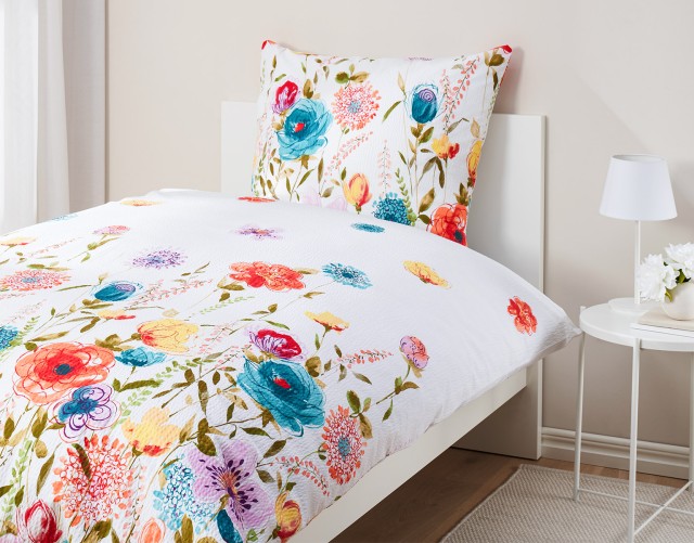 Bettwäsche mit buntem Blumenmuster für warme Sommernächte.