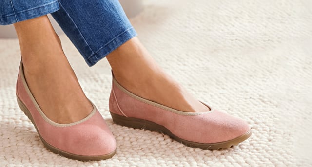 Füße tragen Hallux-Softslipper in Rosa. Füße tragen Hallux-Softslipper in Rosa.