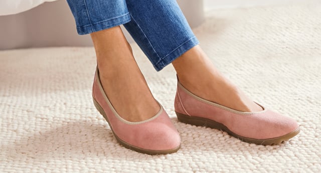 Füße tragen Hallux-Softslipper in Rosa.