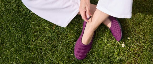 Dame sitzt gemütlich im Gras mit den bequemen Hallux Softslippern. Dame sitzt gemütlich im Gras mit den bequemen Hallux Softslippern.