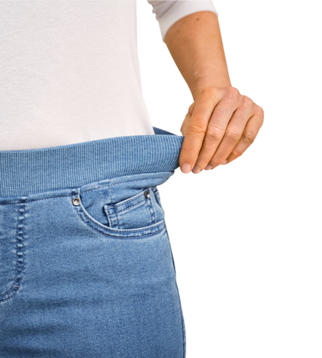Hand verdeutlicht die Dehnbarkeit unserer Wohlfühlhose, indem sie am Bündchen zieht.
