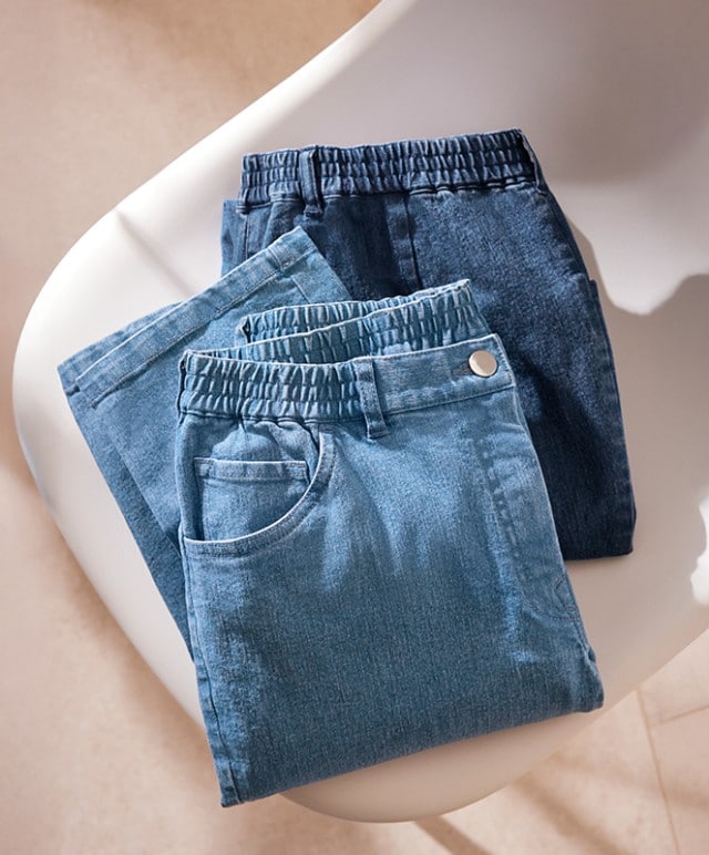 Stylische Jeans in zwei Blautönen liegen auf einem Garadobenstuhl