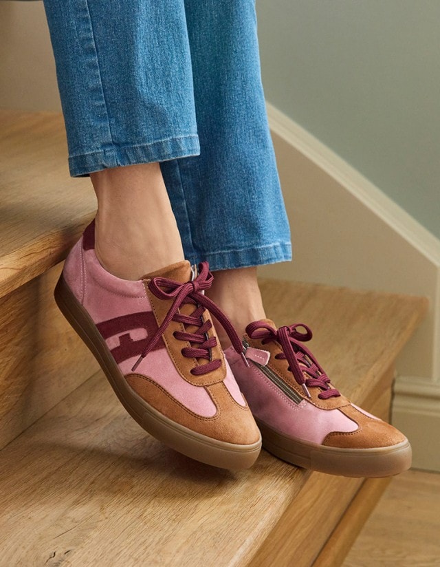 Der Hallux-Schnürer-Soft in der Farbe Rosa/Braun, wir von einer wohnlichen Treppe gezeigt.
