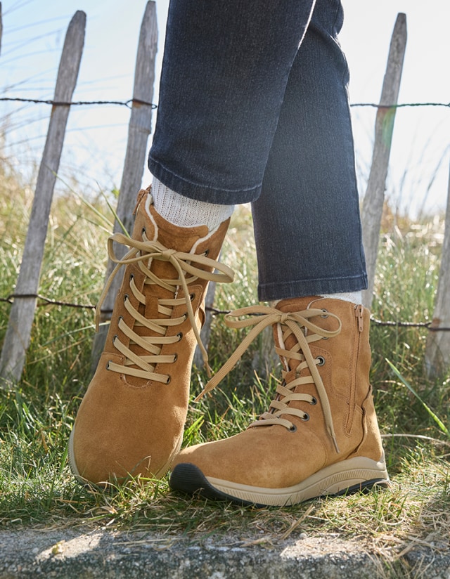 Dame trägt zu einem Herbstspaziergang durch die Natur die bequemen Aktiv-Stiefel Winterfest.