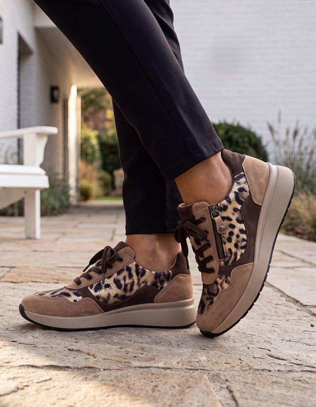 Dane steht auf einem Vorhof und trägt die Hallux-Schnürer Reißverschluss in der Farbe Beige-Leo.