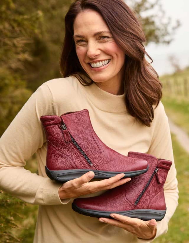 Dame steht an der frischen Luft und trägt den Hirschleder-Bootie Warmfutter in der Farbe Bordeaux