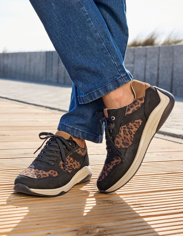 Dame trägt die modernen Aktiv-Schnürer Trittdämpfer mit Leo-Print.
