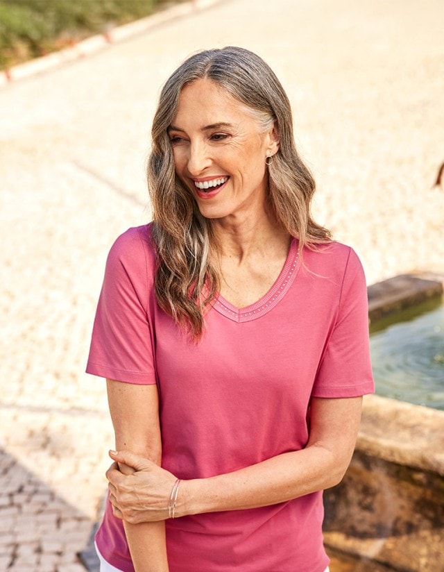 Dame mit beerefarbenem V-Ausschnitt-Shirt auf einem Marktplatz