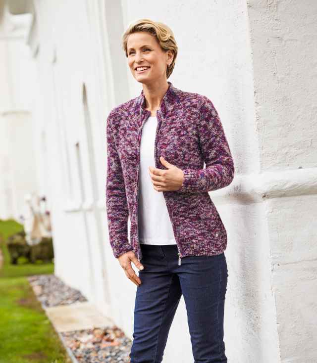Eine lächelnde Frau trägt den geöffneten Strick-Cardigan.
