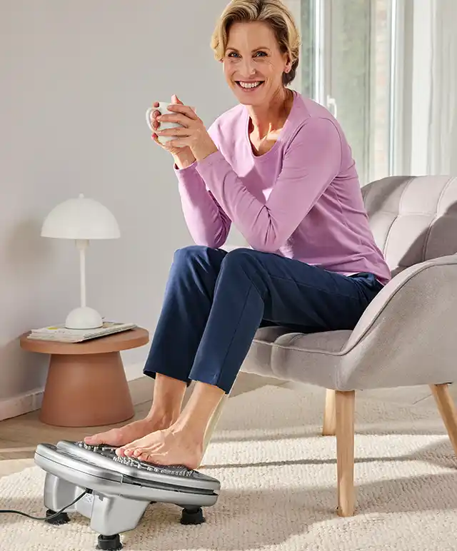Dame entspannt zu Hause mit dem Infrarot Fußmassage-Gerät.