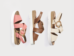Drei Sandalen in Rosa, Braun und Beige mit kreisförmigen Verzierungen und weißen Sohlen, seitlich dargestellt auf weißem Hintergrund.