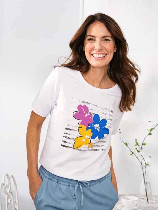 Lächelnde Frau trägt das Baumwoll-Shirt Blumenwiese