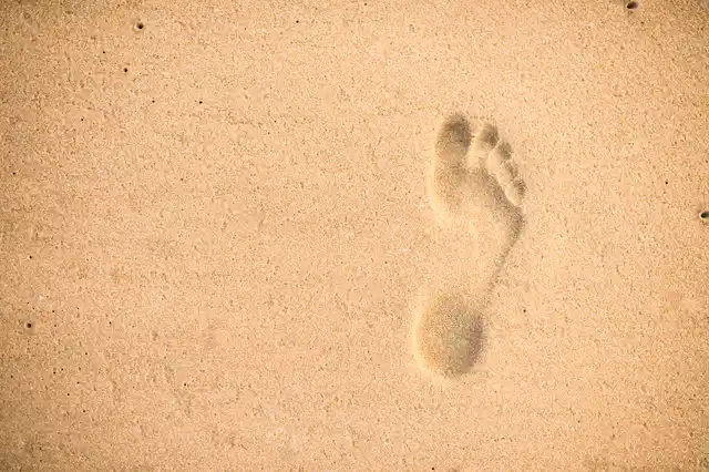 Ein einzelner Fußabdruck im weichen Sand.