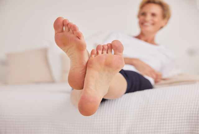 Eine Frau hält glücklich mehrere paar Schuhe in der Hand.