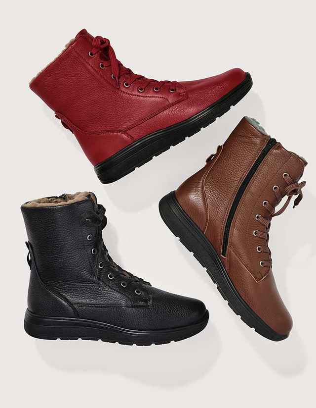 Drei Paar Stiefel in Rot, Braun und Schwarz sind auf neutralem Hintergrund angeordnet. Sie haben ein warmes Innenfutter und Schnürsenkel.